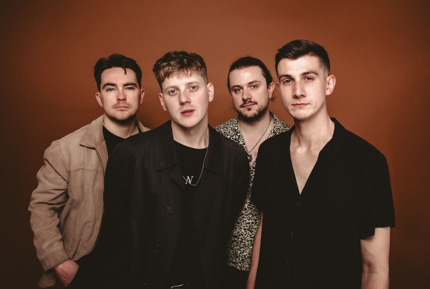 Four men stood in front of a red backdrop